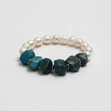 Bracelet with white pearls and large blue rough gemstones on white background