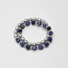 Double-strand bracelet with silver pearls and faceted blue gemstone beads on white background