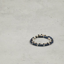 Elegant pearl and blue gemstone beaded bracelet on light gray textured surface