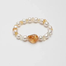 Elegant bracelet with white pearls, amber stones, and clear beads on white background