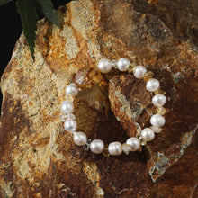 Pearl and citrine beaded bracelet displayed on textured brown rock with green leaf