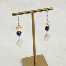 Drop earrings with citrine, clear, blue, and pearl beads on brass display stand