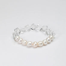 Elegant bracelet featuring white pearls and clear geometric crystal beads on white background
