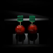 Elegant earrings featuring green rectangular tops and large red round stones with a marbled pattern