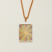 Tibetan Echo rectangular pendant necklace with colorful swirling pattern on gold chain