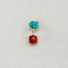 Turquoise and red gemstone dangle earring with gold connector on beige background