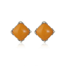Pair of square orange gemstone stud earrings with silver prong setting on white background