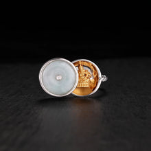 Silver ring with a jade stone lid featuring a hidden golden Jambhala Buddha statue inside
