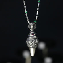 Sterling silver pendant necklace with intricate filigree and colored gemstones on black background