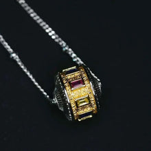 Gold and silver ornate pendant necklace with rectangular colored gemstones on silver chain