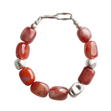 Close-up of a bracelet featuring polished red agate and silver beads with a silver clasp