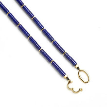 Blue cylindrical bead necklace with gold accents and unique gold clasp on white background