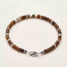 Brown tiger eye bead bracelet with silver accents and detailed clasp on white background