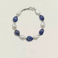 Bracelet with alternating blue and white oval beads on a white background