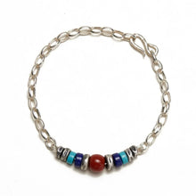 silver chain bracelet with red, blue, and turquoise beads on white background