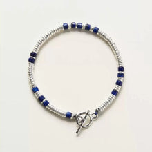 silver and blue beaded bracelet with toggle clasp on white background