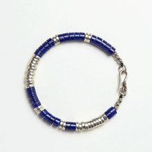 beaded bracelet with blue and silver discs and a silver hook clasp on white background