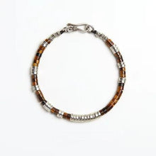 brown and silver beaded bracelet with metal clasp on white background