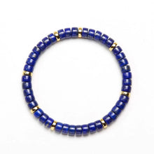 Blue lapis lazuli bead bracelet with spaced gold-tone accents on white background