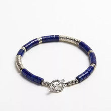 Blue and silver beaded bracelet with toggle clasp on white background