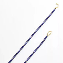 blue beaded necklace with gold clasp on white background