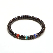 Dark brown beaded bracelet with red, turquoise, and blue accent beads on white background