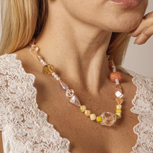Close-up of woman wearing colorful beaded necklace with white lace top