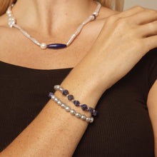 Close-up of woman's wrist and neck showcasing handmade pearl and blue gemstone bracelets and necklace