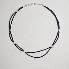 Elegant double-strand dark blue beaded necklace with silver accents and clasp on white background